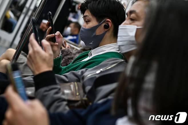 마스크를 착용한 일본 도쿄 시민들이 지하철을 이용하고 있다. © AFP=뉴스1