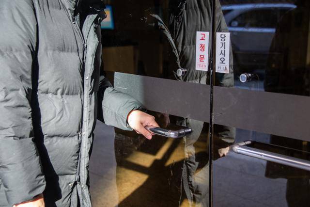 왼손잡이 김모(25)씨가 고정상태인 왼쪽 편 문을 열어보고 있다. 왼손잡이들은 오른쪽 문을 당겨 열기 어렵지만, 출입문 중 대다수의 왼쪽은 붙박이로 고정된 상태다.