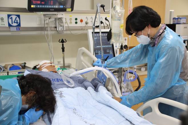 뇌사 상태로 병상에 누운 손현승씨 곁에 선 형 손봉수씨(오른쪽)와 어머니. [사진 한국장기조직기증원]