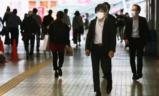 일본 도쿄 시민들이 18일 마스크를 착용하고 길을 걷고 있는 모습. 도쿄=AP연합뉴스
