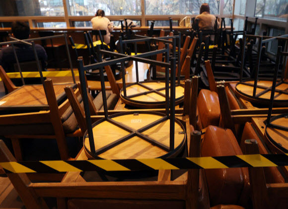 수도권 사회적 거리두기가 1.5단계로 격상된 19일 서울시내 한 커피매장에 의자와 테이블 일부가 치워져 있다. 연합뉴스