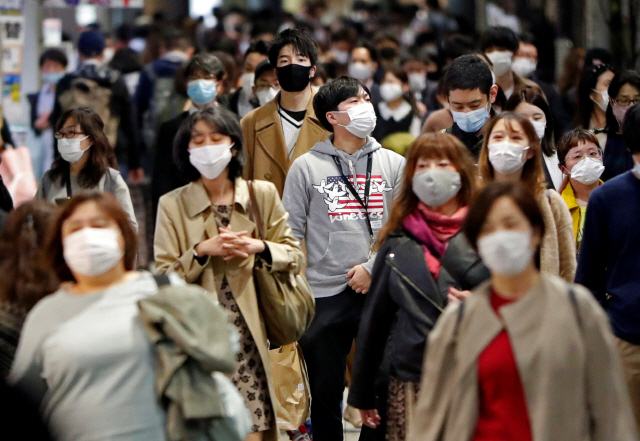 일본 도쿄의 한 거리에서 19일 마스크를 쓴 시민들이 걷고 있다. /로이터연합뉴스