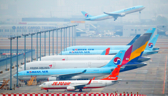 지난 18일 인천국제공항 주기장에 제주항공,대한항공,아시아나항공 등의 비행기가 집결해있다.연합뉴스
