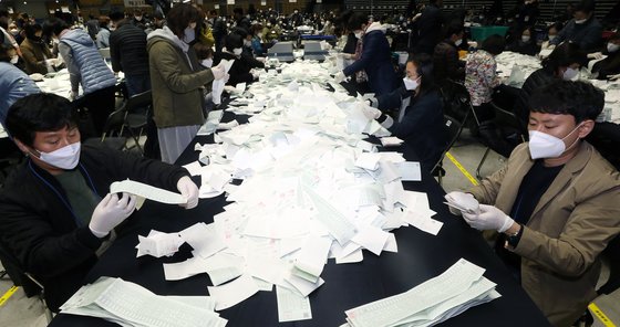 제21대 국회의원선거 투표가 종료된 15일 오후 서울 송파구 올림픽공원 KSPO돔에서 개표사무원들이 투표함을 열어 투표지 분류 작업을 하고 있다. 뉴스1