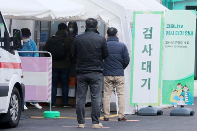 수도권 사회적 거리두기 2단계 격상을 하루 앞둔 23일 오전 서울 중구 국립중앙의료원 선별진료소에서 검사를 받으려는 시민들을 순서를 기다리고 있다. 뉴시스