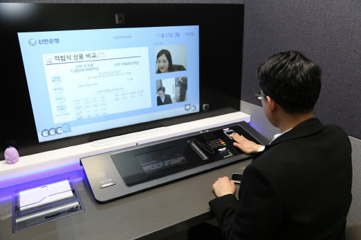한 소비자가 24일 서울 중구 신한은행 서소문지점에 오픈한 미래형 혁신 점포 ‘디지택트 브랜치’에서 금융 업무를 보고 있다.(사진=신한은행 제공)