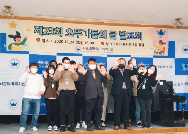 제23회 오뚜기들의 글발표회가 비대면으로 개최된 24일 서울시립뇌성마비복지관 직원들이 27명의 작가 탄생을 축하하는 퍼포먼스를 하고 있다. 서울시립뇌성마비복지관 제공
