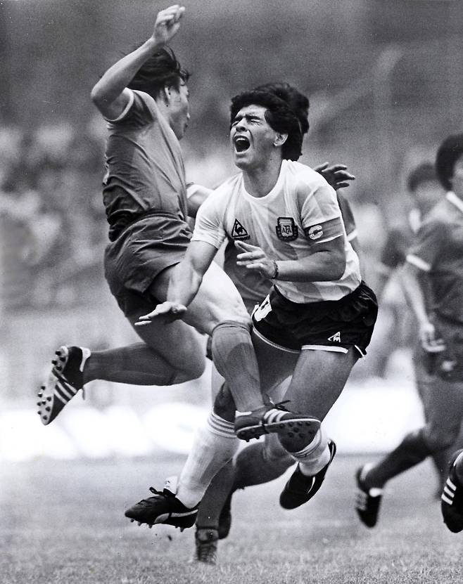 아르헨티나의 축구의 전설 디에고 마라도나가 25일 심장마비로 향년 60세로 별세했다. 사진은 1986년 멕시코 월드컵 한국과 아르헨티나전에서 허정무가 마라도나를 거칠게 수비하는 모습.[연합뉴스]