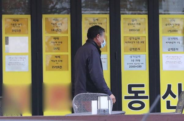 지난 달 12일 부산 수영구 남천동 삼익비치 아파트 근처 부동산을 한 시민이 지나가고 있다. /김동환 기자