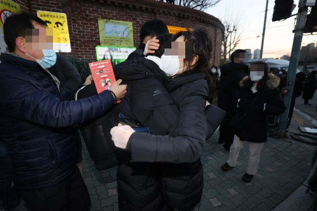 3일 오후 서울 용산고등학교에서 수능을 마친 한 수험생이 어머니와 포옹하고 있다. 연합뉴스
