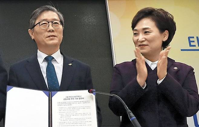 지난 1월 서울 영등포역에서 열린‘영등포 쪽방촌 주거 환경 개선 및 도시 정비를 위한 공공 주택 사업 추진 계획’기자회견에서 변창흠(왼쪽) 한국토지주택공사 사장이 MOU(양해각서) 합의서를 들어 보이고 있다. 옆에서 김현미 국토교통부 장관이 박수를 치고 있다. /연합뉴스