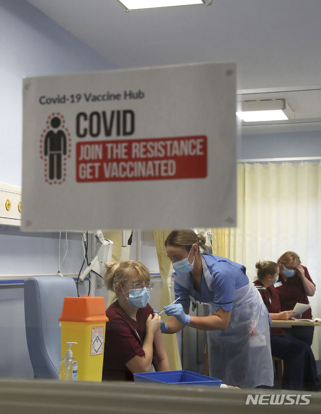 [에딘버러=AP=뉴시스]8일(현지시간) 영국 에딘버러의 웨스턴 제너럴 병원에서 한 간호사가 코로나19 백신 접종을 받고 있다. 2020.12.8.