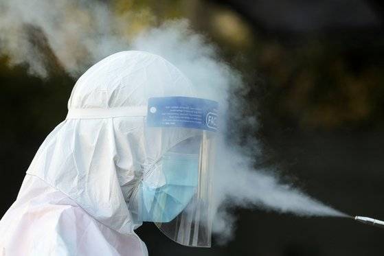 지난달 1일 루마니아 부쿠레슈티에 있는 일 포프 구급차 서비스 본부에서 구급대원이 코로나바이러스 감염 방지를 위한 소독 절차를 거치고 있다. 로이터=연합뉴스