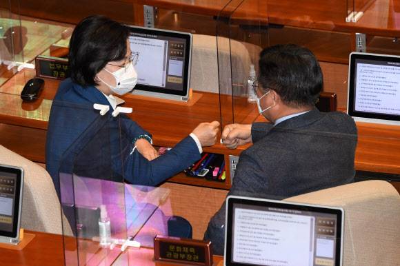 검찰 보란 듯… 공수처법 통과 자축 - 야당의 비토권을 무력화하는 내용의 고위공직자범죄수사처법 개정안이 10일 국회를 통과하는 가운데 추미애(왼쪽) 법무부 장관이 본회의장에서 더불어민주당 소속 윤호중 법제사법위원장과 주먹인사를 하고 있다. 공수처법은 찬성 187명, 반대 99명, 기권 1명으로 가결됐다.연합뉴스