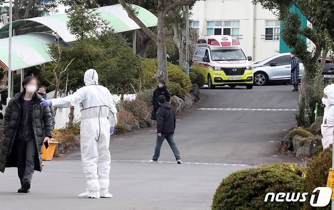 15일 오전 코로나19 확진자가 발생한 제주시 봉개동 대기고등학교에서 검체검사를 받은 학생들이 빠져나오고 있다. 제주도는 학교 체육관에 워킹스루 선별진료소를 설치하고 학생과 교직원 470명을 대상으로 검체 검사를 실시하고 있다.2020.12.15/뉴스1 © News1 오현지 기자