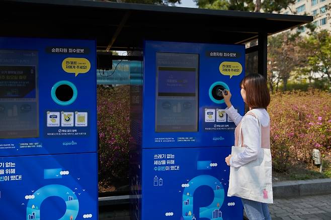 한 이용자가 수퍼빈이 만든 AI 재활용 수거로봇 '네프론'에 PET병을 집어넣고 있다./사진제공=수퍼빈