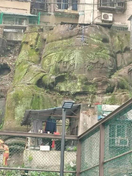 중국 충칭의 아파트 단지에서 발견된 대형 석각은 머리가 훼손됐으나 두 손과 배, 옷깃 등의 모습은 생생하게 남아있다. [중국 남방도시보망 캡처]