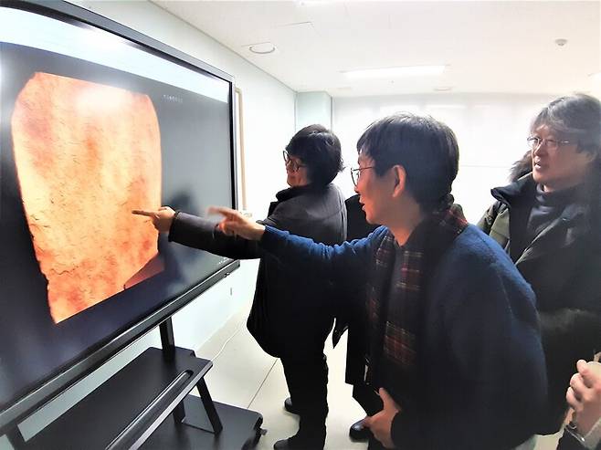 지난달 18일 한국기술교육대에서 열린 무술오작비 디지털 판독회의 모습. 참석한 학자들이 연단에 몰려나와 대형 모니터에 뜬 비석 명문 글자의 디지털 이미지들을 살펴보며 의견을 나누고 있다.