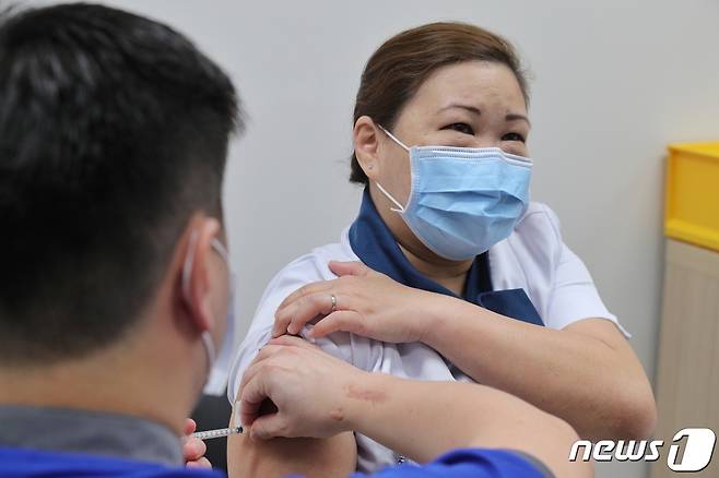 싱가포르에서 국립전염병센터 직원들이 처음으로 화이자 코로나19 백신을 접종받았다.  © 로이터=뉴스1