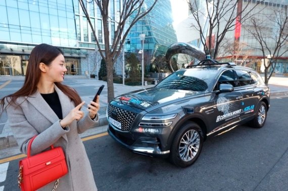 서울시 상암 5G 자율주행 시범지구에서 한 사용자가 모바일 앱으로 5G 자율주행차 'A1(에이원)'을 인근 주차장으로 보내고 있다/LG유플러스 제공