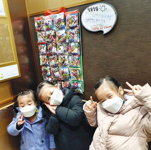 어린이들이 엘리베이터에 성탄선물을 부착하고 사진을 촬영했다.