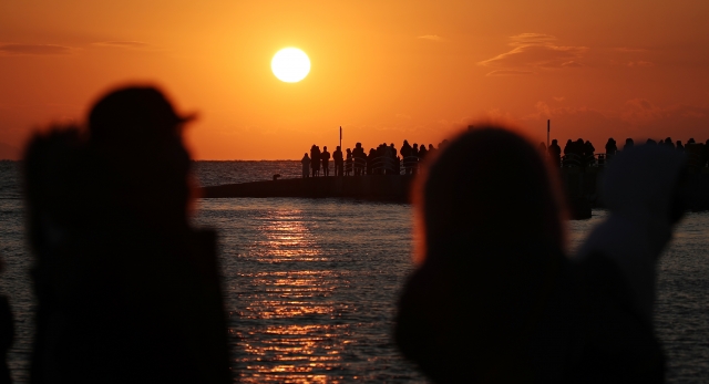 지난달 31일 인천 을왕리 앞 바다를 찾은 시민들이 올해 마지막 해넘이를 바라보고 있다. 연합뉴스
