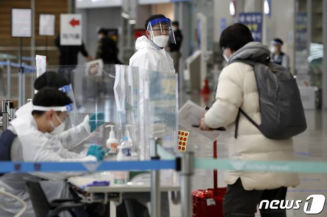 지난해 12월30일 오후 인천국제공항 입국장에서 해외발 입국자들이 방역 당국의 안내를 받고 있다. © News1