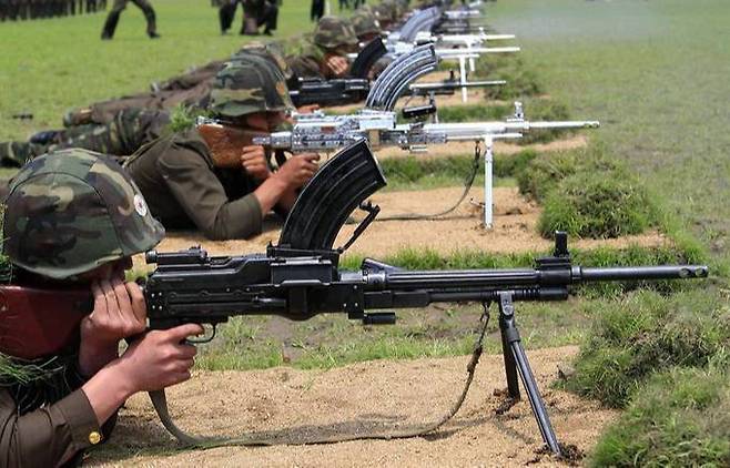 북한군 병사들이 전방 표적지를 향해 기관총을 사격하고 있다. 세계일보 자료사진