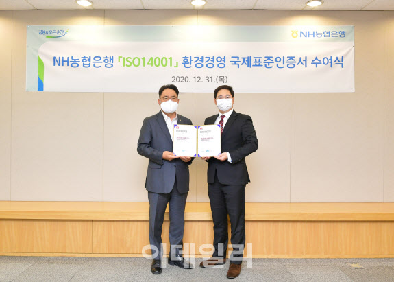 지난 12월 31일 서울시 중구에 위치한 농협은행 본점에서 NH농협은행 지준섭 농업·녹색금융부문 부행장(왼쪽)과 로열서트코리아 이권상 대표(오른쪽)가 ISO 14001 인증서 수여식을 갖고 기념촬영을 하고 있다. (농협은행 제공)