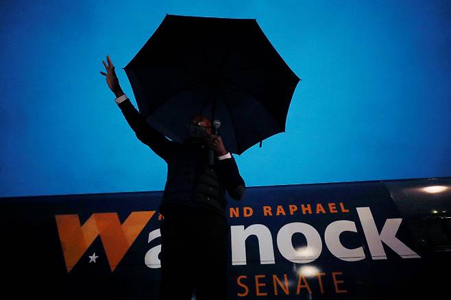 미 상원의원에 출마한 라파엘 워녹 민주당 후보가  빗속에서 드라이브인 유세전을 펼치고 있다./로이터 연합뉴스