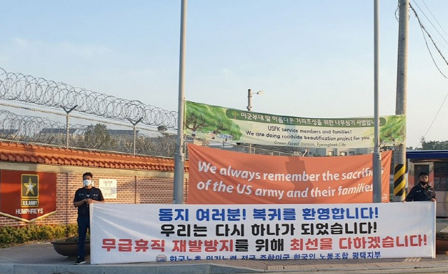 주한미군 한국인 근로자들이 75일간의 무급휴직을 끝내고 다시 출근을 시작한 지난해 6월 15일 경기도 평택시 캠프 험프리스 앞에서 전국 주한미군 한국인 노조 관계자들이 환영 현수막을 걸고 출근 인사를 하고 있다.          /평택=연합뉴스