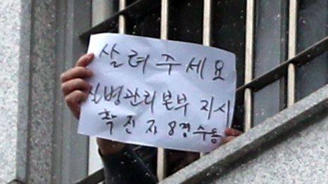 동부구치소에서 발생한 신종 코로나바이러스 감염증(코로나19) 확진자가 하루 200명 넘게 쏟아지며 누적확진자가 762명까지 증가한 가운데 29일 오후 서울 송파구 동부구치소에서 한 수용자가 최창살 사이로 "살려주세요" 라고 쓴 피켓을 들어 보이고 있다. 이 수용자는 질병관리본부가 특별관리사동 각 방에 확진자를 8명씩 과밀 수용하고 있다며 손글씨로 고발하고 있다. /2020.12.29