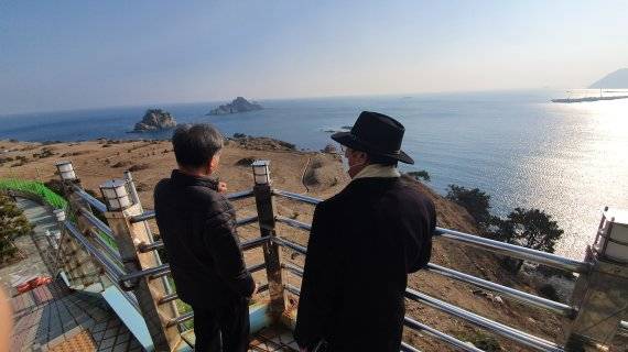 ▲부산 남구 용호동 SK뷰아파트 입대위원회(대표 문영대) 관계자가 오륙도 및 용호 씨사이드 사업지를 바라보고 있다. 기자 촬영