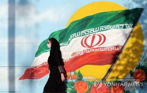 이란 국기 앞을 지나는 테헤란 시민/EPA=연합뉴스
