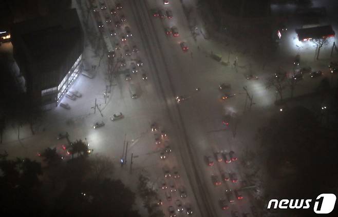 서울 전역에 대설주의보가 발효된 6일 오후 서울 송파구 서울스카이에서 바라본 서울 도심에 눈이 쌓여 차량들이 서행하고 있다. 2021.1.6/뉴스1 © News1 이동해 기자