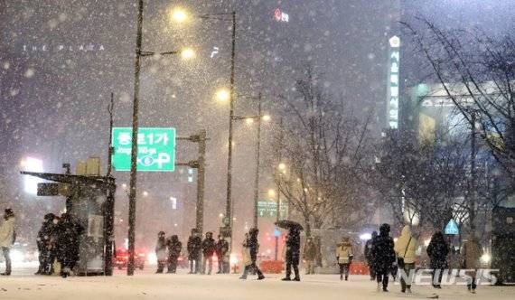 연일 한파가 이어지며 눈이 내리고 있는 6일 오후 서울 종로구 광화문네거리에서 시민들이 발걸음을 옮기고 있다. 뉴시스