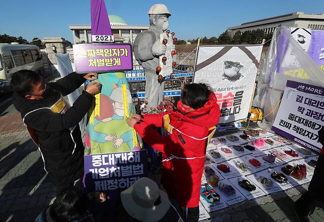 중대재해기업처벌법 제정을 요구하며 단식을 이어가고 있는 농성자들이 2일 국회 정문 앞 단식농성장에서 열린 ‘2021년 맞이 중대재해 기업처벌법 제정 촉구 및 소원 나눔 행사’에서 산재 사고로 희생된 이들을 추모하며 소원 쪽지를 ‘중대재해기업처벌법 소원탑’에 붙이고 있다. 강창광 선임기자