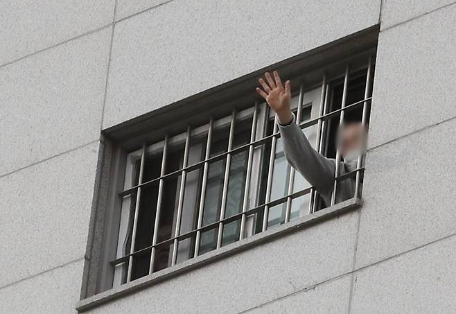 지난 3일 서울 송파구 동부구치소에서 한 재소자가 창문 사이로 손을 흔들어 보이는 모습. 뉴스1