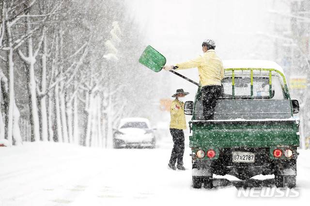 [광주=뉴시스] 변재훈 기자 = 광주·전남에 폭설이 내린 30일 오전 광주 북구 운암1동 일대에서 공무원들이 염화칼슘을 뿌리며 제설 작업을 하고 있다. (사진=광주 북구 제공) 2020.12.30. photo@newsis.com