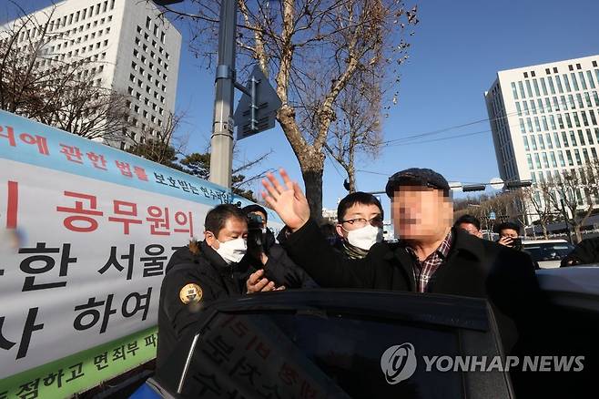 경찰에 연행되는 대검 앞 방화 용의자 (서울=연합뉴스) 류영석 기자 = 5일 오전 서울 서초구 대검찰청 앞에서 윤석열 검찰총장 응원화환에 불을 붙인 남성이 경찰에 연행되고 있다. 2021.1.5 ondol@yna.co.kr