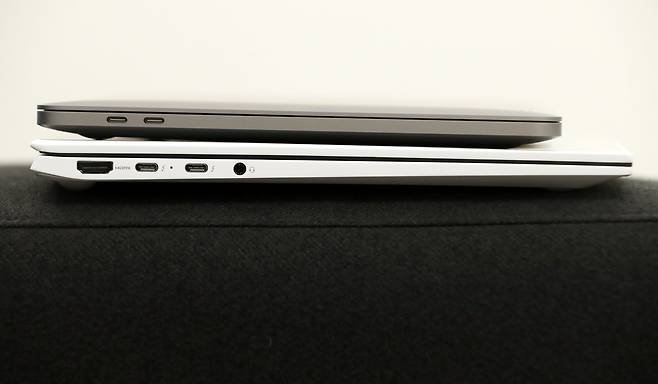 맥북 프로(위)와 그램 16을 겹쳐놓은 모습. 맥북 왼쪽 옆면엔 선더볼트4/USB-C타입 단자 두개, 그램엔 HDMI단자(왼쪽부터), 선더볼트4/USB-C타입 단자 두개, 이어폰 단자가 있다. /장련성 기자