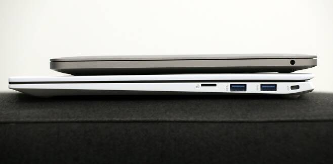 맥북 프로(위)와 그램 16을 겹쳐놓은 모습. 맥북 오른쪽 옆면엔 이어폰 단자, 그램엔 마이크로SD카드 슬롯(왼쪽부터), USB-A타입 단자 두개가 있다. /장련성 기자
