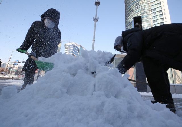 밤사이 많은 눈이 내린 7일 오전 서울 강남구 봉은사역 사거리에서 인근 건물 관계자들이 제설작업을 하고 있다. /연합뉴스