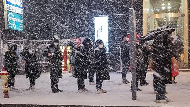 북극발 찬공기 영향으로 중부지역과 내륙을 중심으로 한파가 이어지고 있는 6일 저녁 서울 강남역 인근에서 시민들이 눈발을 맞으며 버스를 기다리고 있다. 뉴스1