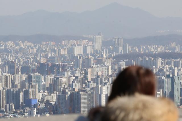 지난달 31일 서울 남산에서 한 시민이 고층 아파트를 바라보고 있다. 연합뉴스