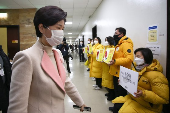 백혜련 법사위 법안심사제1소위원회 위원장(왼쪽)이 7일 국회에서 중대재해기업처벌법을 후퇴한 내용으로 합의한 더불어민주당과 국민의힘을 규탄하는 정의당 의원들 앞으로 지나가고 있다. 오종택 기자