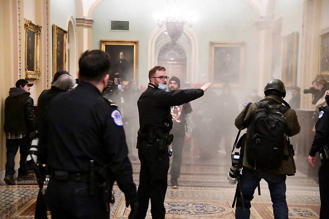 미국 워싱턴 연방의회 건물에 난입한 트럼프 대통령 지지자들이 6일(현지시간) 경찰의 진압 시도에 맞서 소화기를 쏘며 저항하고 있다.  워싱턴|로이터연합뉴스