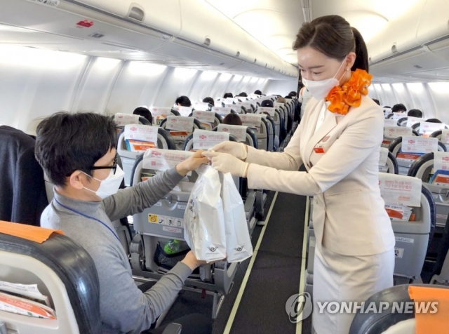 제주항공이 지난해 12월 일본 상공을 비행하고 돌아오는 무착륙 국제 관광비행을 실시했다. 이날 한 탑승객이 기내에서 면세품을 사고 있다.
