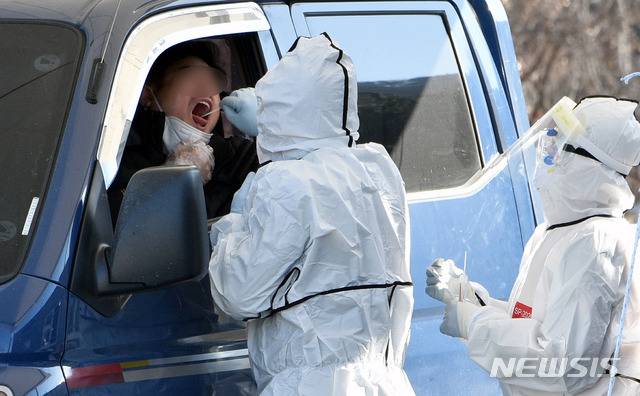 [대구=뉴시스] 이무열 기자 = 전국에서 신종 코로나바이러스 감염증(코로나19) 지역감염이 이어지고 있는 가운데 7일 오전 대구 수성구 대구스타디움 제3주차장에 마련된 드라이브스루 코로나19 임시선별검사소에서 의료진이 검체 채취를 하고 있다. 2021.01.07. lmy@newsis.com