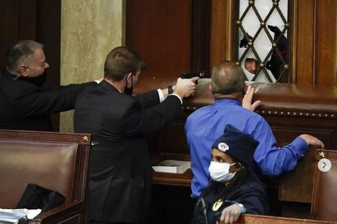의회 경비원들이 상원회의장 출입문을 봉쇄한 채 권총으로 시위대를 위협하고 있다. 인스타그램 캡처